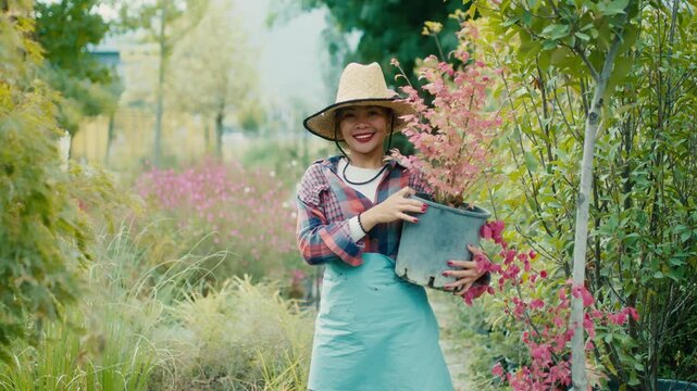 Woman with potted plant in a vibrant garden