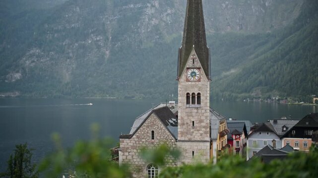 Hallstatt church architecture Austria. Beautiful historic cathedral with tower and clock in the center of the alpine village on the lake.