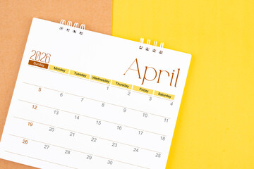 April 2026 desk calendar on brown and yellow, Planning for business.