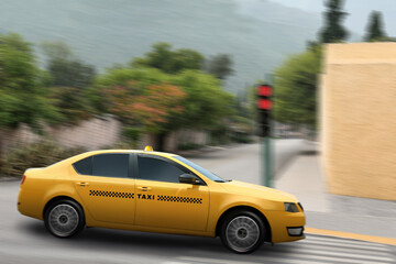 Yellow taxi car driving on city street, motion blur