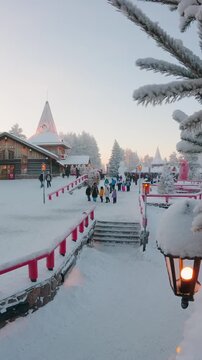 Rovaniemi, Finland - 25th december, 2025: Timelapse famous Santa Claus Village Rovaniemi Lapland cold winter evening with festive lights tourists snow covered buildings Christmas travel destination