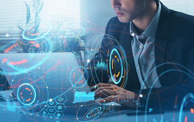Man in suit using laptop with futuristic digital interface graphics overlay, in creative business setting, technology concept on office background