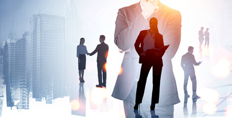 Silhouettes of business people overlaid on city buildings, in a creative double exposure style,...