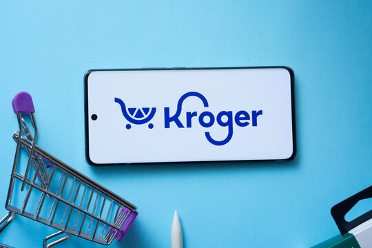 Dhaka, Bangladesh- 03 July 2025: Smartphone displaying Kroger logo with shopping cart on a blue background.
