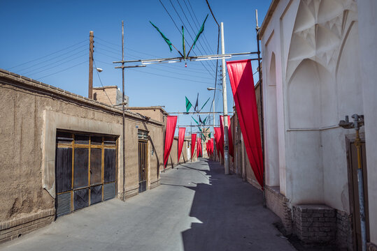 Red flags on the narrow street of Old Town of Kashan, Iran