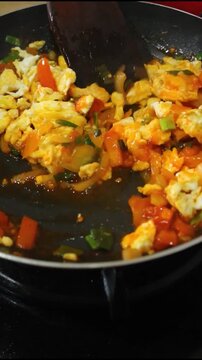 Professional Chef Stirring Delicious Scrambled Eggs With Fresh Tomatoes And Vegetables