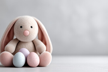 Stuffed rabbit is sitting on a table with four eggs