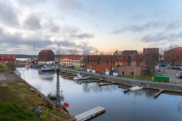 Obraz premium Picturesque European Port Town at Dusk with Boats and Historic Architecture