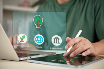 Businessman analyzing ESG (Environmental, Social, and Governance) data on a digital tablet. Sustainable business strategy, green energy investment, and corporate responsibility concept.