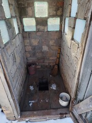 Rustic Outdoor Stone Latrine in Winter Landscape
