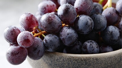 Close up of a bunch of ripe purple grapes in a bowl