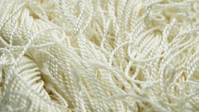 A close-up of synthetic white twisted fiber showing the intricate textures and patterns of the material