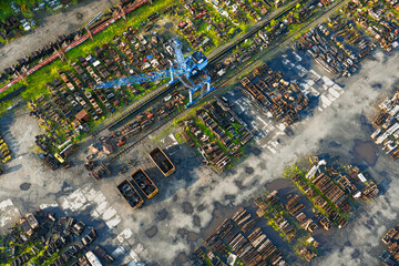 A mobile crane operating at the scrapyard of the ČSM coal mine, handling heavy metal materials in an industrial mining environment.
