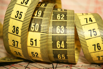 Yellow tailor's measuring tape in centimetres at working desk
