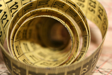 Yellow tailor's measuring tape in centimetres at working desk