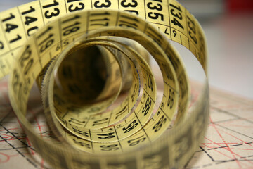 Yellow tailor's measuring tape in centimetres at working desk