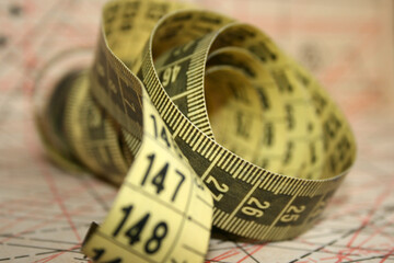 Yellow tailor's measuring tape in centimetres at working desk