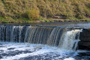 The threshold of the Tosnensky (Gertovsky) waterfall on a sunny October day. Leningrad region, Russia