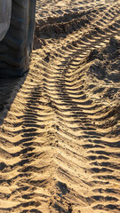 Pattern of tracks of heavy machinery across soft sand on a residential construction site in Florida, for concepts of industry, access, and ephemera