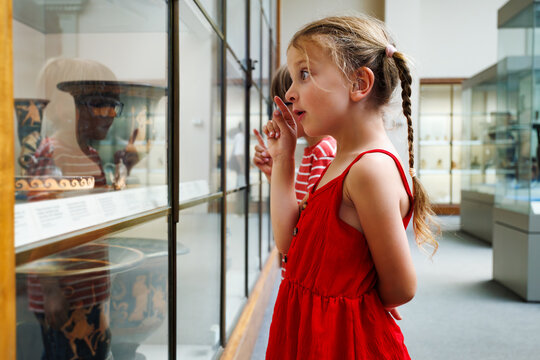 Children explore fascinating historical items behind glass case