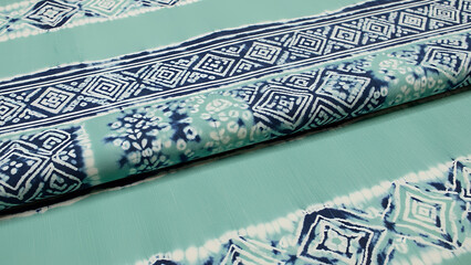 Adire fabric with vibrant patterns and green tones showcasing traditional textile art