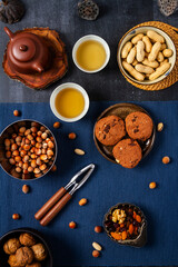 Food themed still life with crockery, various nuts and tea. Flat lay. Top view.