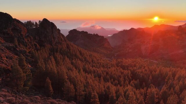 Gran Canaria volcanic mountains at sunset, aerial landscape, pine forest and volcanic rocks and the setting sun on the island of Gran Canaria, Canary Islands, Spain