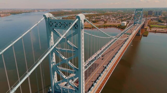 Aerial drone overhead of bridge and traffic over river - Philadelphia Ben Franklin Bridge and Delaware River towards Camden, New Jersey