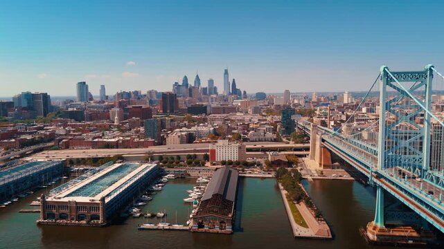 Fly Back Zoom Out with Aerial Drone - Philadelphia Skyline and Ben Franklin Bridge and Delaware River, City Skyline and bridge with river.