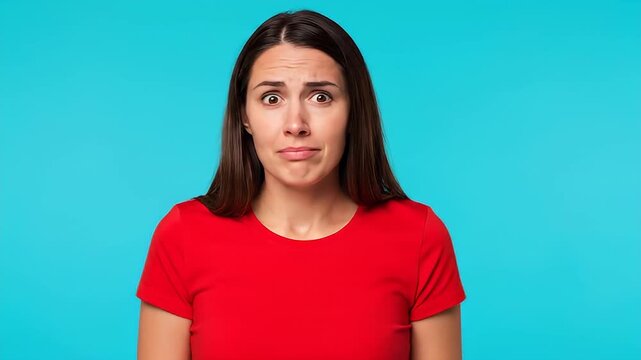 Confused Woman Shrugs Shoulders Expressing Uncertainty Against Blue Background.
