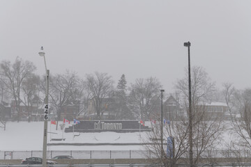 Obraz premium City of Toronto sign on slope towards railway, Gardiner Expressway, and Lake Shore Blvd W, seen from Martin Goodman Trail during a snow storm on 2026-01-15