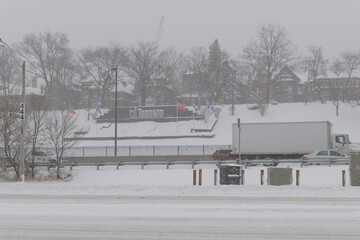 Obraz premium City of Toronto sign on the side of a hill facing Gardiner Expressway, public transit rails, and Lake Shore Blvd W, during a major weather event on 2026-01-15