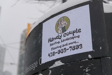 Obraz premium Handy Couple paper bill posted to a message board in downtown Toronto