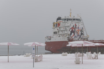 Naklejka premium CSL Welland (self-unloading bulk carrier) with sugar cargo docked at Redpath Sugar Refinery located at, 95 Queens Quay E, during a snow storm on 2026-01-15 in Toronto (Sugar Beach view)