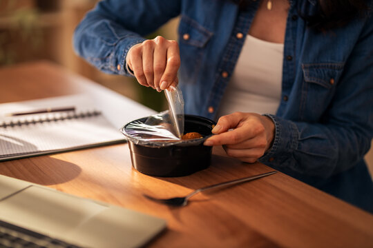 Woman opening meal container for office lunch break