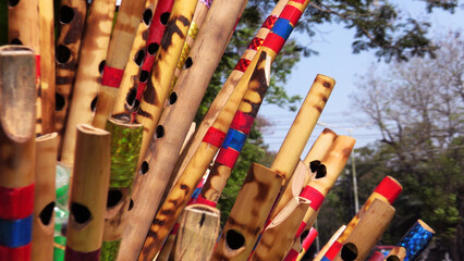 A collection of decorated wooden flutes displayed by a street toy seller © Reji VR