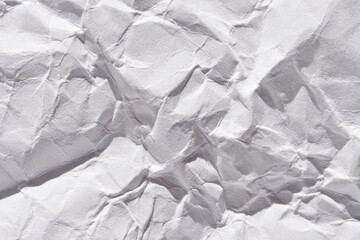 Fototapeta premium Crumpled white paper texture with detailed creases and shadows creating a rough surface.
