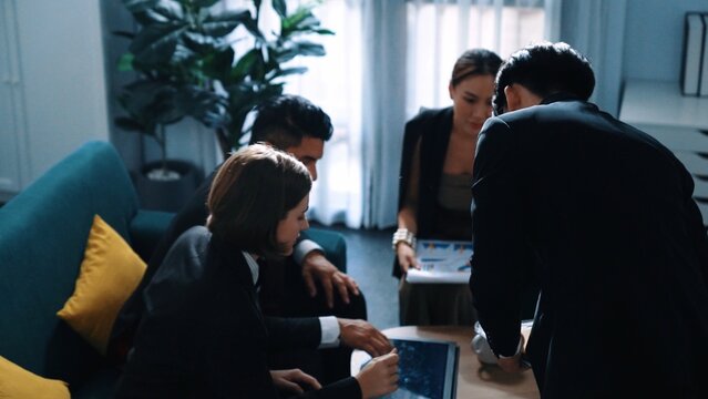 Top view of skilled businessman sharing marketing plan to diverse investors while diverse people looking data analysis chart and asking question at business meeting. Creative business. Directorate.