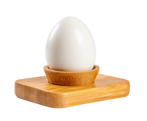 Single white chicken egg sitting upright in a natural bamboo egg cup holder with a square base, representing a healthy and nutritious breakfast meal in a minimalist style