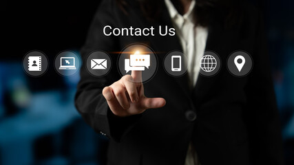 A professional dressed in business attire uses a touchscreen to interact with digital icons representing contact options, exemplifying modern communication in a corporate setting. Gantry