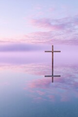 a colourful sky over lake, a beautiful sunrise, a wooden cross at the edge of the lake with a reflection on the water, foggy and misty