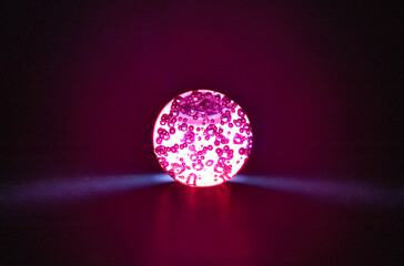 illuminated red glass crystal magic transparent ball isolated on black background