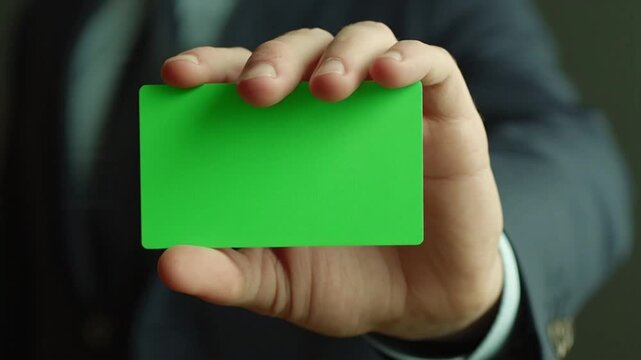 Professional hand presenting a chroma key green card for customizable content or digital insertion