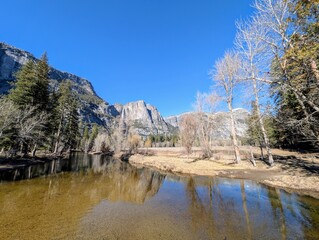 Obraz premium Yosemite National Park's iconic Yosemite Falls reflecting in the Merced River on a clear winter day