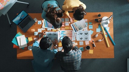 Top view of business team write graphic logo on meeting table with colorful sticky notes and design while explain idea. Project manager sharing idea and explain concept art to smart team. Symposium.