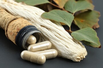 Herbal supplements and plant materials are positioned on a black surface with a focus on natural health products and herbal remedies