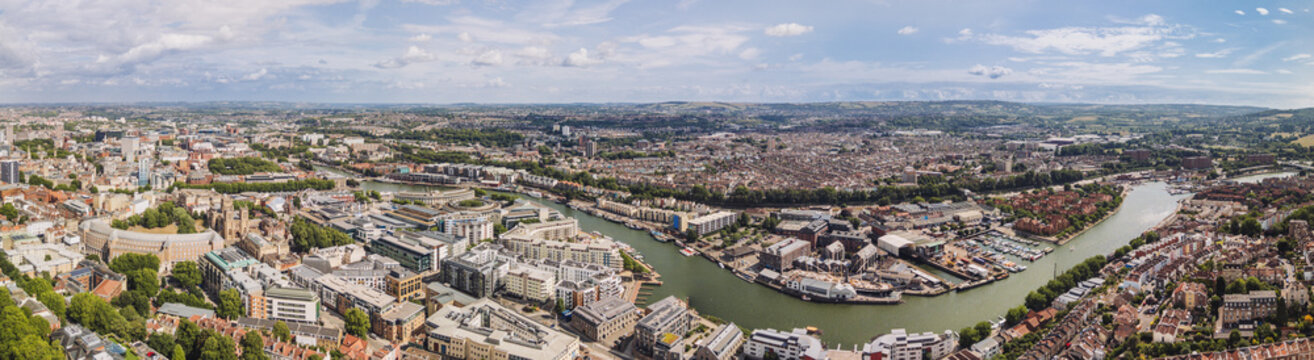 Bristol England: 28th July 2025: Drone view of Bristol Harbourside, surrounded by historic buildings along the River Avon with city in background. Panorama