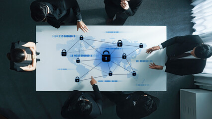 A business team engages in a strategic meeting about data security, displaying a world map and digital icons that represent network protection and privacy concerns. Trope