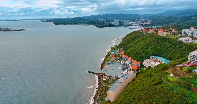 Flight over the rocky coast covered with lush greenery. Approaching the luxurious oceanfront El Conquistador Resort in Puerto Rico.