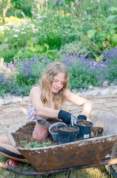 girl in garden with flower pots preparing soil for spring planting